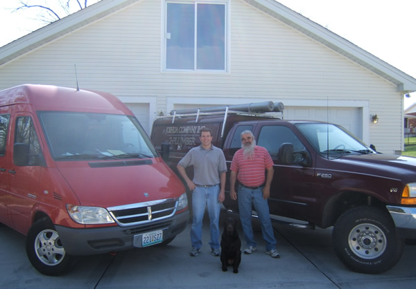 Mike and Josh Brockmann standing between Joshua Plumbing service vehicles, 2006